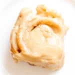 A piece of caramel roll on a white plate.