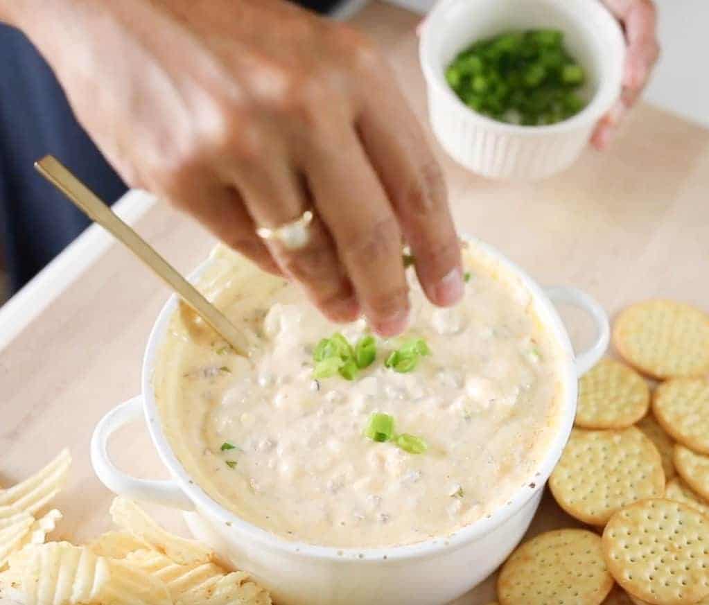 garnishing cheese dip with green onion