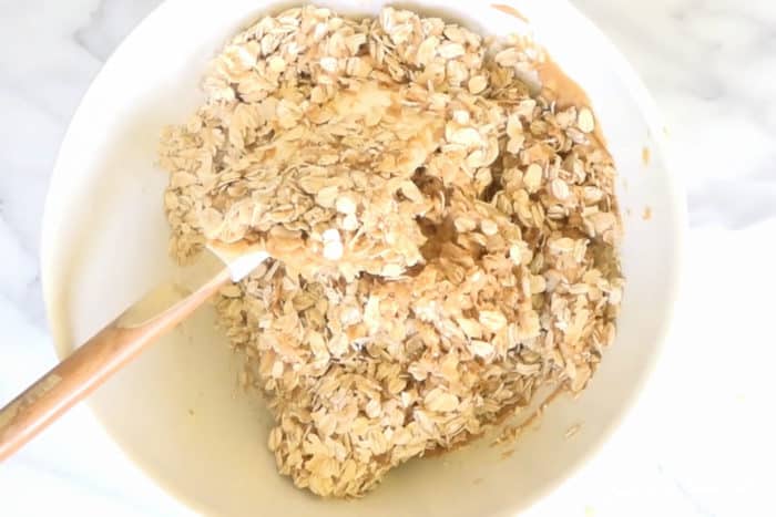 mixing granola rice peanut butter and honey with a spatula