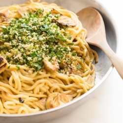 A pan full of lemon spaghetti with fried artichokes.