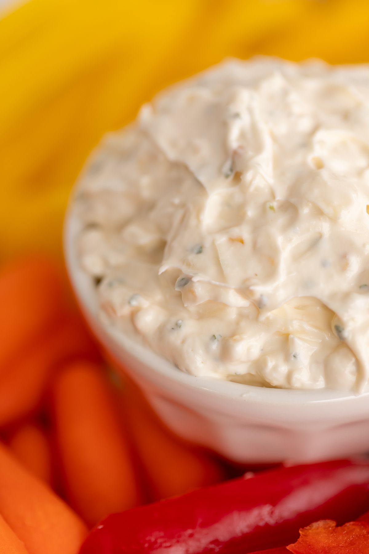 A white bowl full of veggie dip