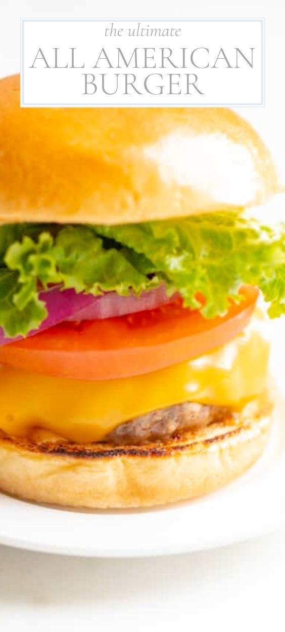 White background with a white plate featuring a classic All American burger, stacked with cheese, tomato, onion and lettuce.