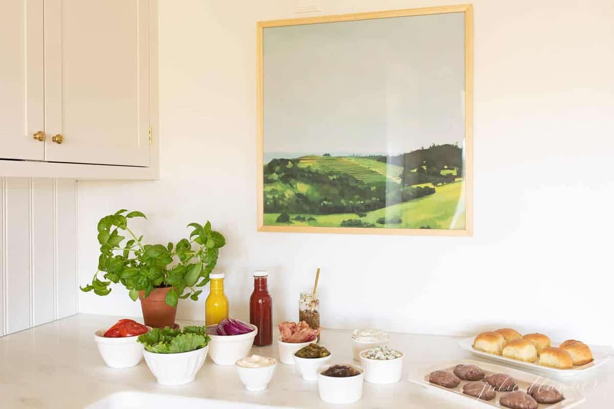 An array of toppings and condiments displayed for a burger bar.