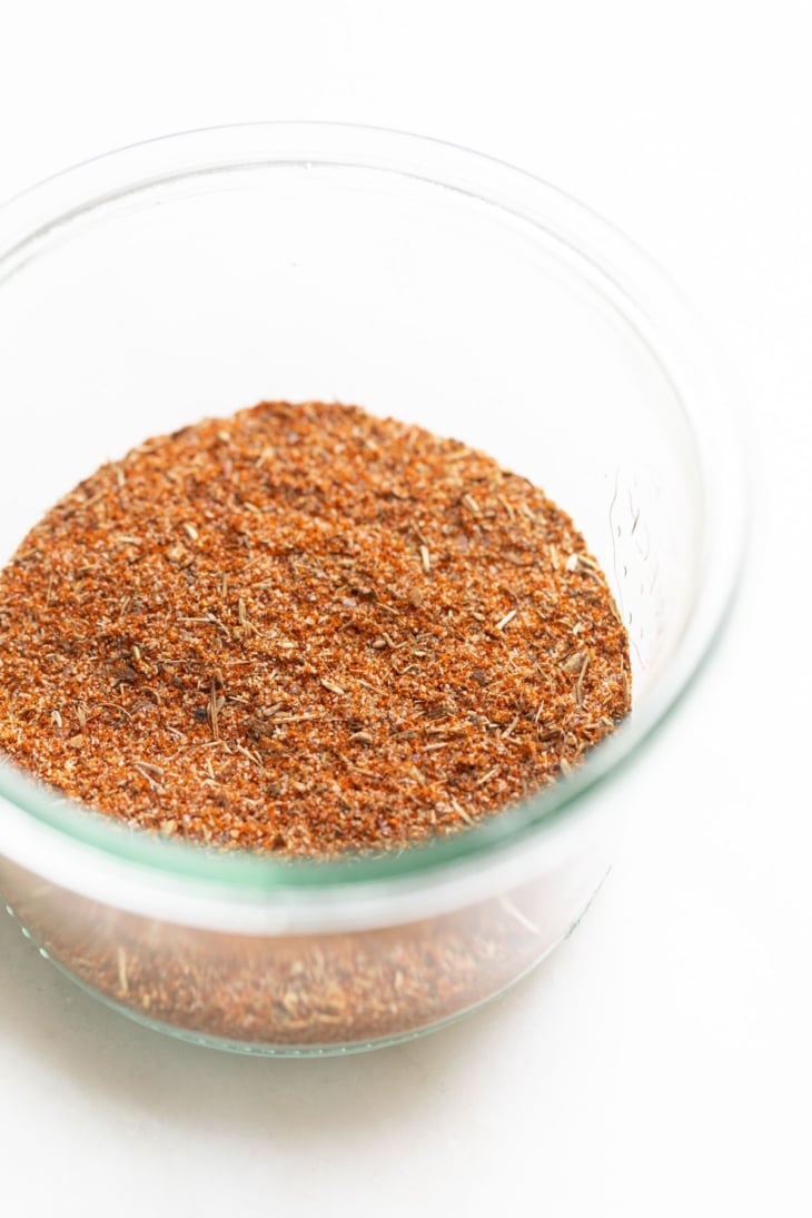 A small glass jar full of blackened seasoning blend.