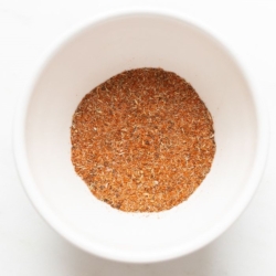 A small white bowl full of blackened seasoning blend.