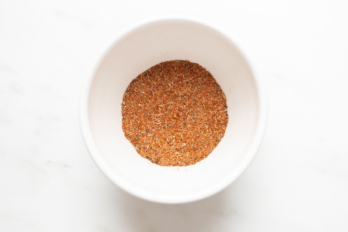 A small white bowl full of blackened seasoning blend.