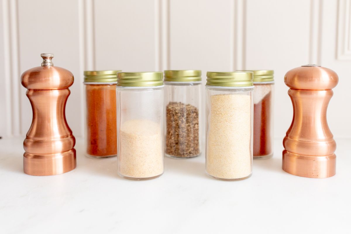 Small glass jars of spices to make a homemade blackened seasoning blend.