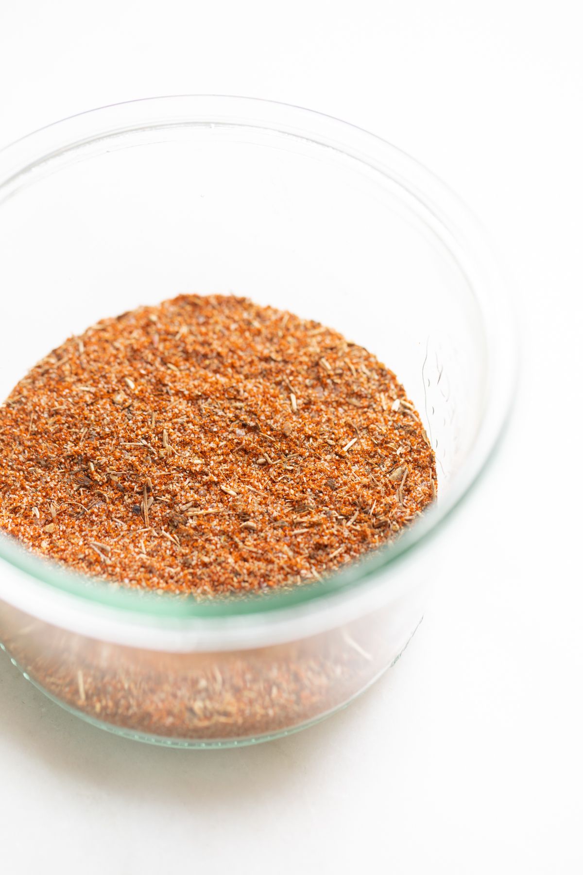 A small glass jar full of blackened seasoning blend. 