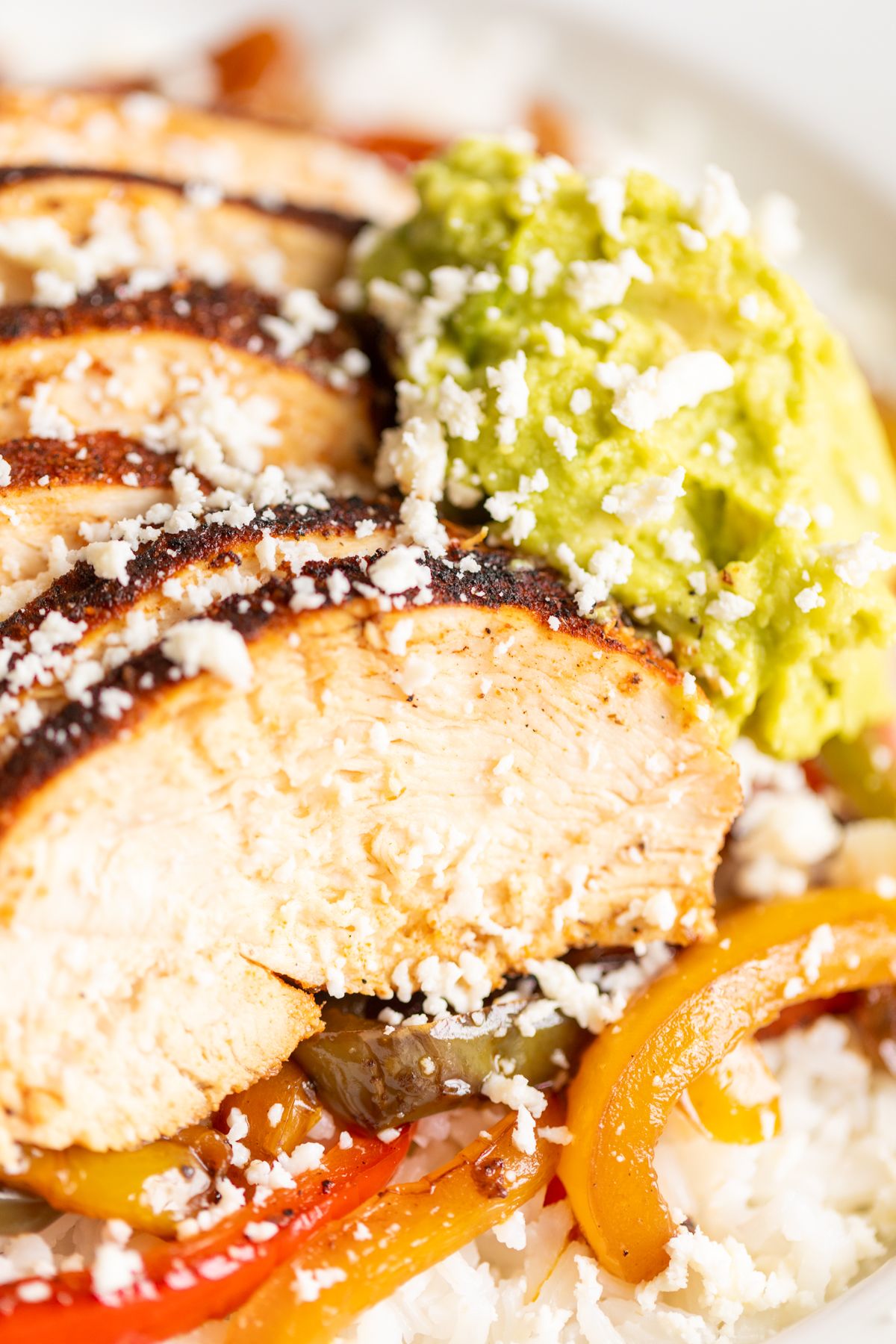 A chicken fajita bowl topped with guacamole.