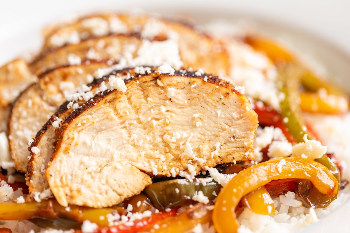 A chicken fajita bowl served over white rice and sauteed peppers.