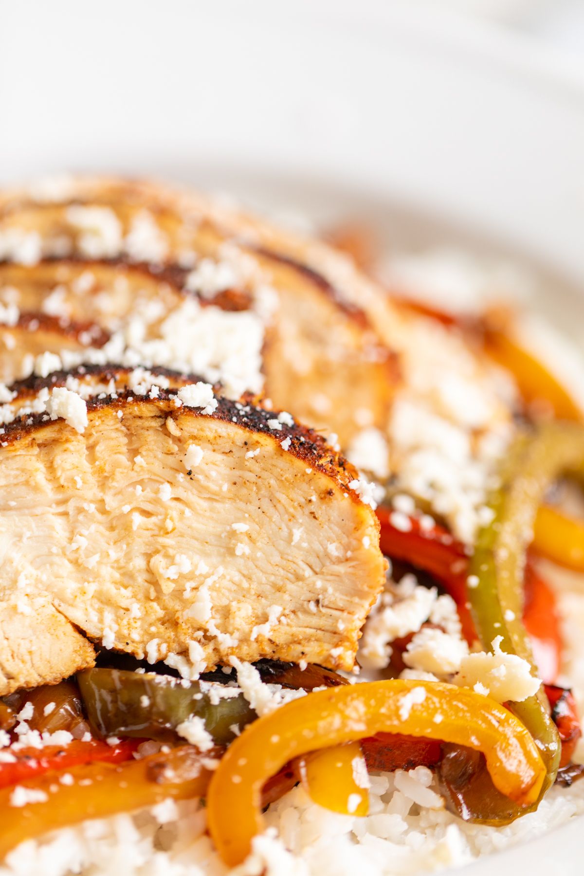 A chicken fajita bowl served over white rice and sauteed peppers.