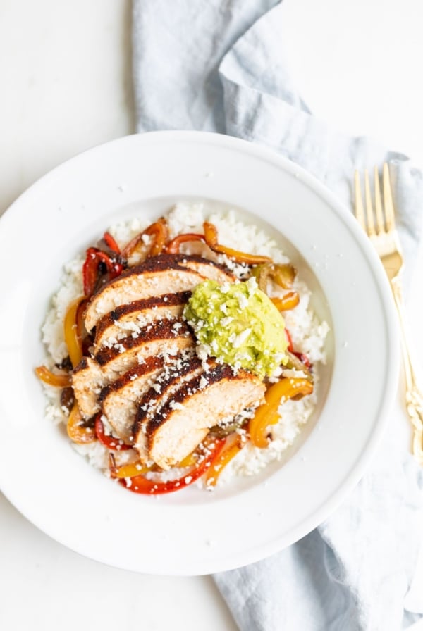 A chicken fajita bowl topped with guacamole.