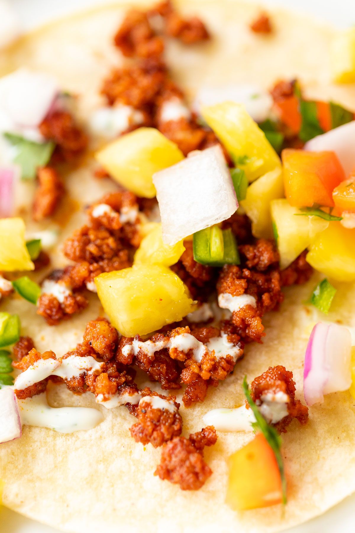 A chorizo taco topped with pineapple salsa