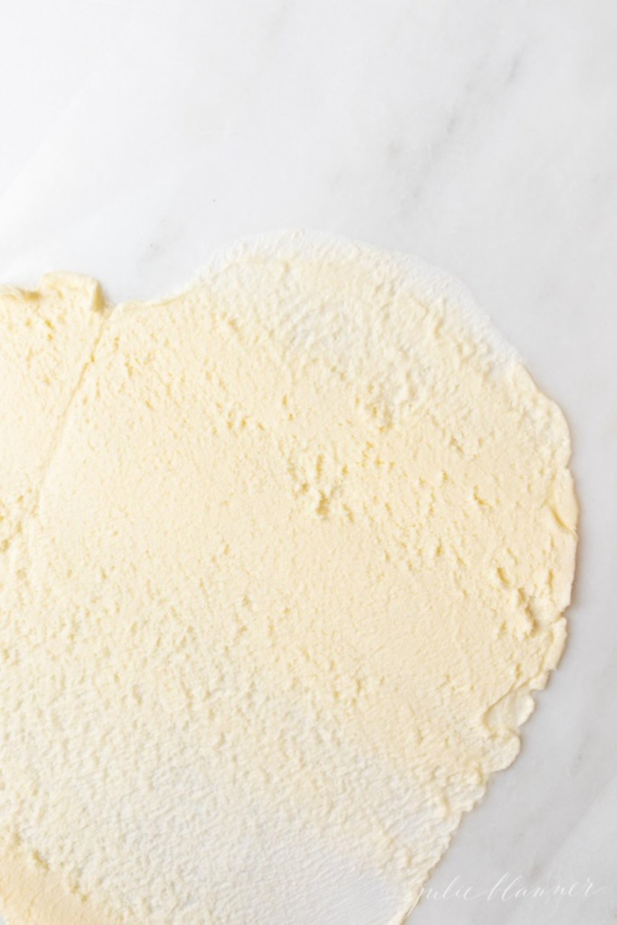 A stick of butter that has been flattened with a rolling pin in a tutorial for softened butter.