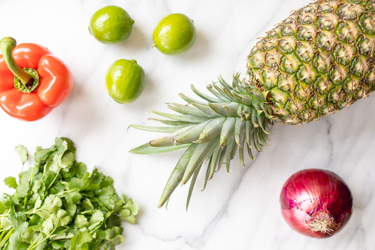 Ingredients for pineapple salsa laid out on a marble countertop