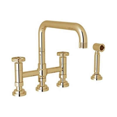 An unlacquered brass kitchen faucet against a white background.