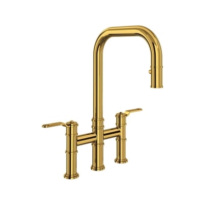 An unlacquered brass kitchen faucet against a white background.