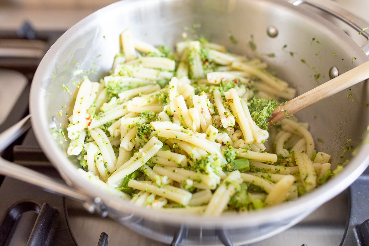 A broccoli pasta recipe inside a stainless steel pot on a stovetop