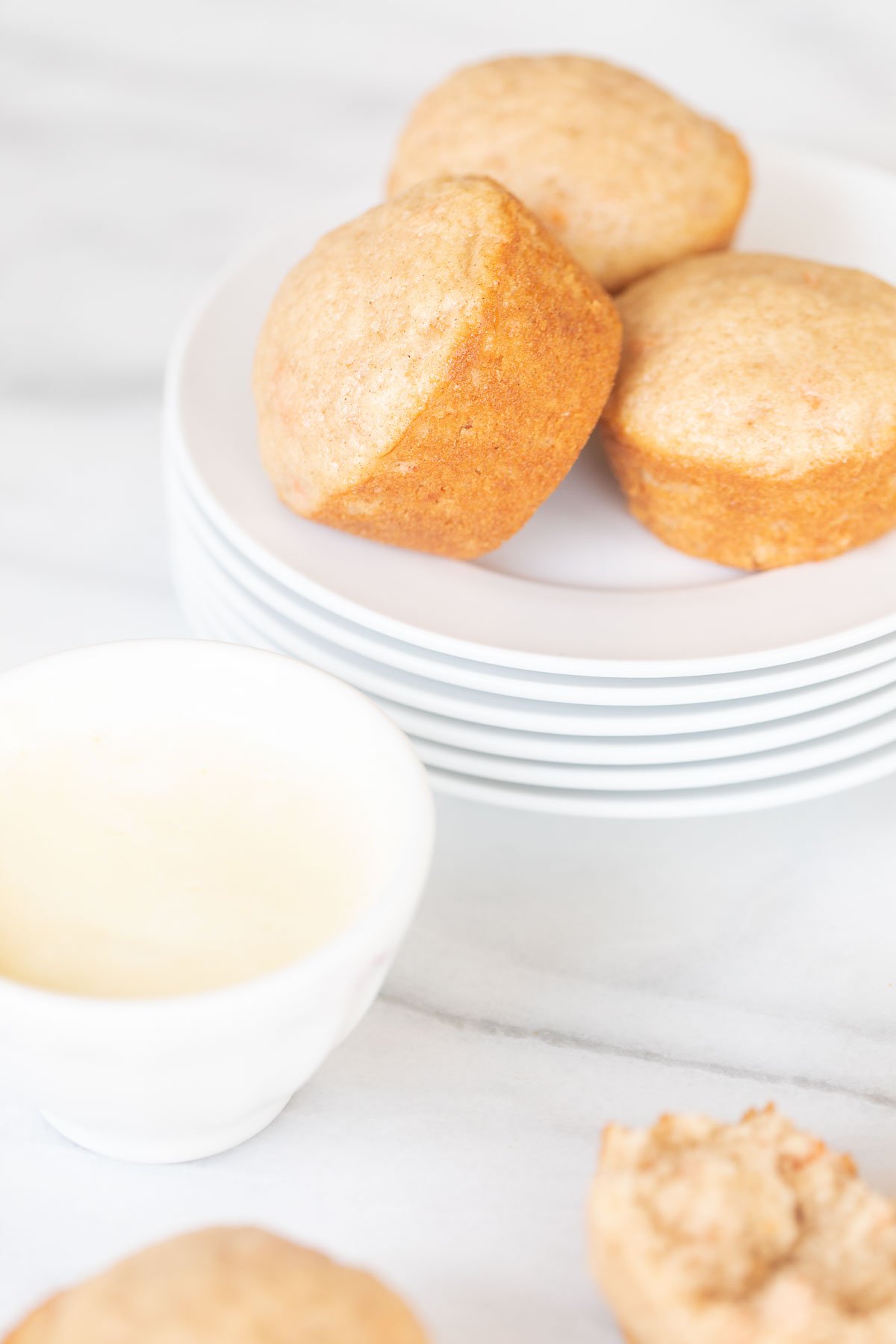 A plate with Carrot Cake Muffins and a bowl of butter.