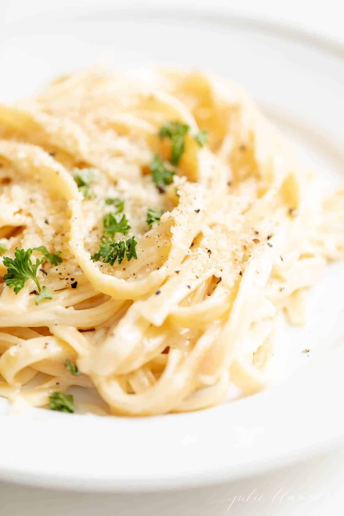 Close up of fettuccine noodles covered in an alfredo sauce recipe