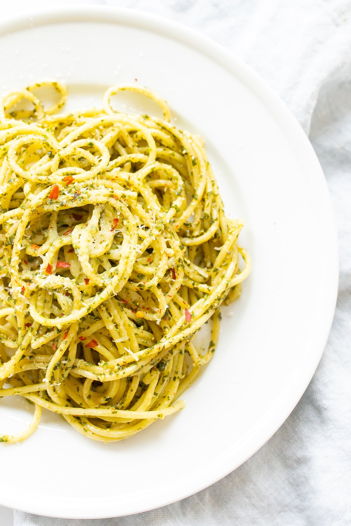 Pesto pasta recipe on a white plate.