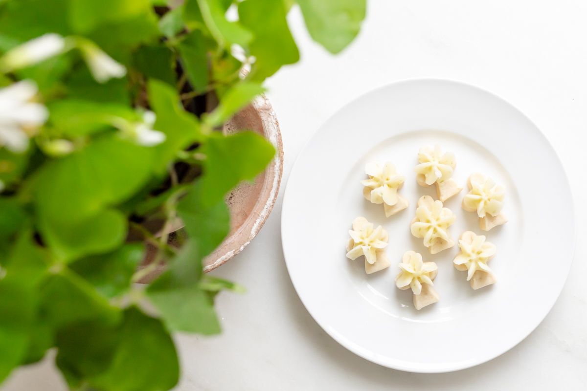 A white platter full of frosted lime cookies.