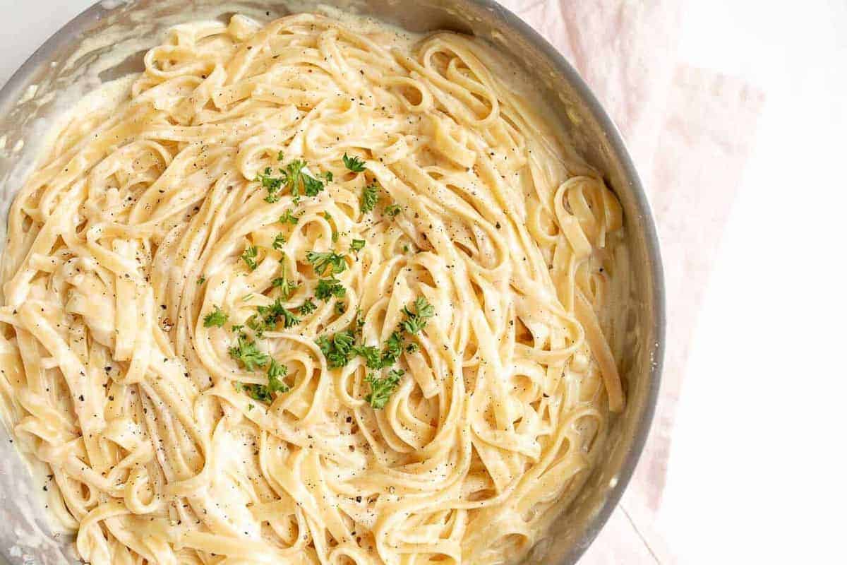 Fettuccine Alfredo in a metal pan.