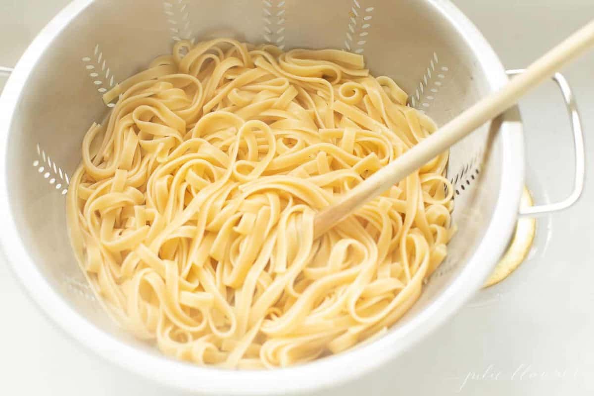 Strainer full of fettuccine noodles