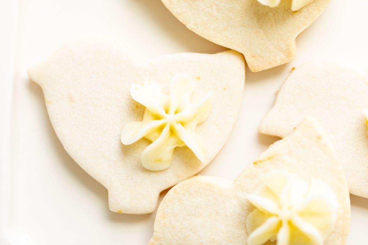 Frosted lemon shortbread cookies in a bird shape.