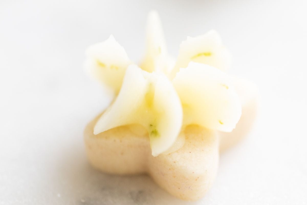 A frosted lime cookie on a white plate