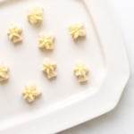 A white platter full of frosted key lime cookies.