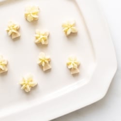 A white platter full of frosted key lime cookies.