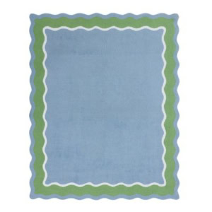 Rectangular light blue rug with wavy green and white borders.