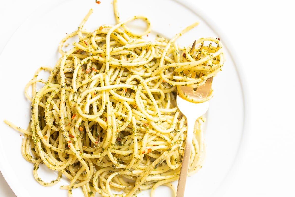 A plate of spaghetti with pesto pasta on it.