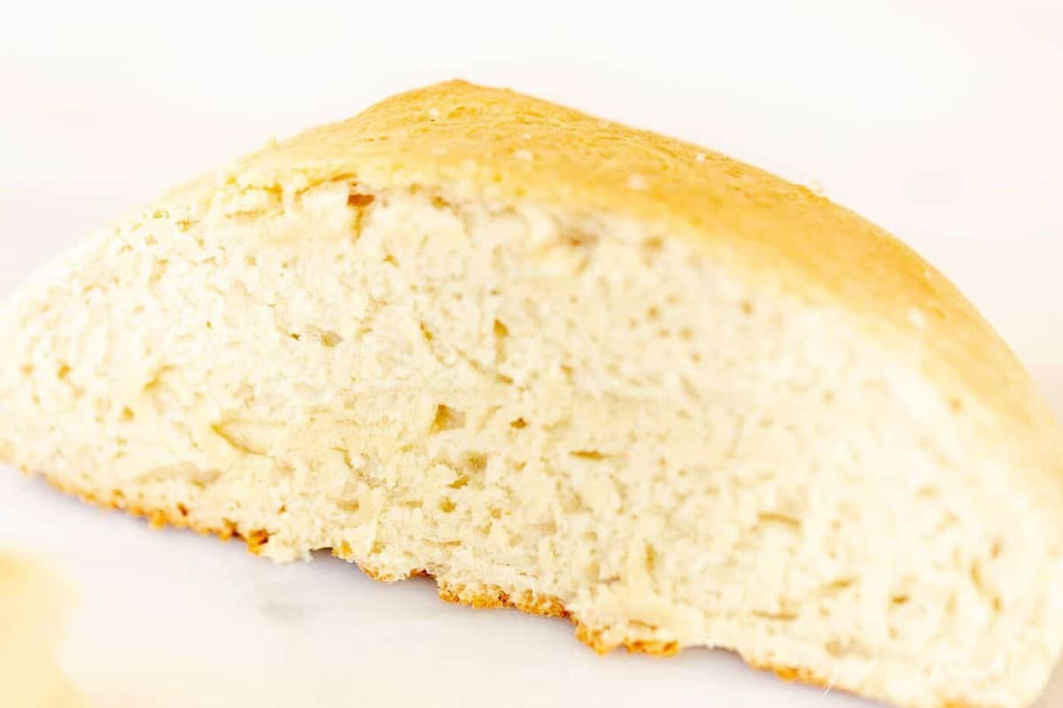 A slice of homemade bread made with rapid rise yeast on a marble surface.