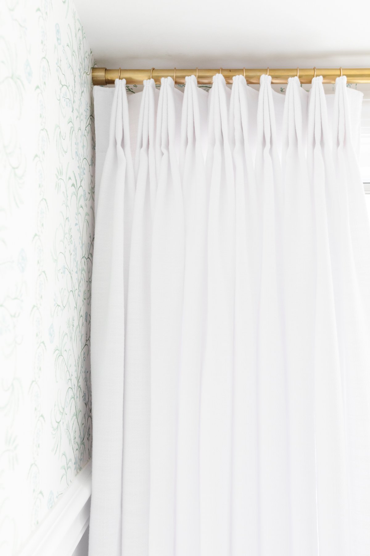 White curtains in a room with pastel wallpaper