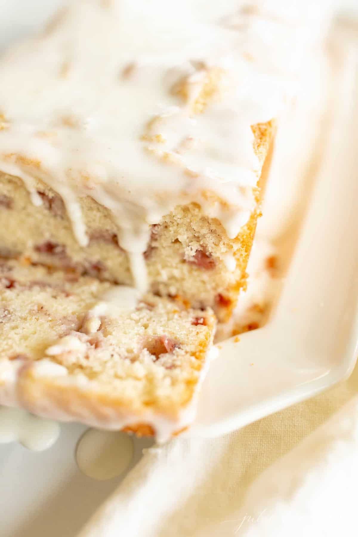 A loaf of strawberry bread covered in glaze.