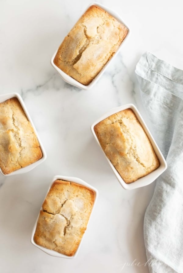 Small loaves of poppy seed bread on a white countertop.