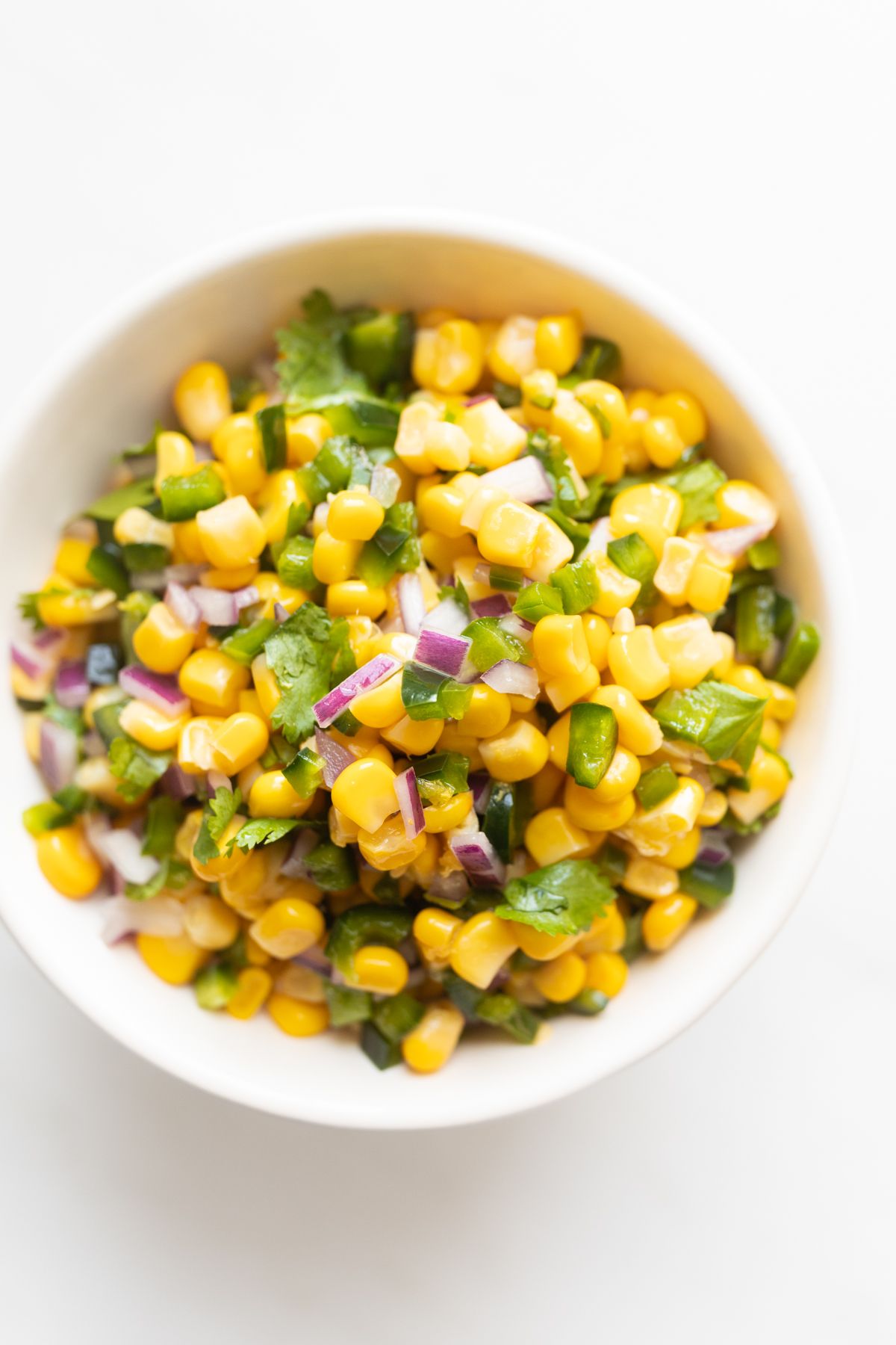 A white bowl full of homemade Chipotle corn salsa.