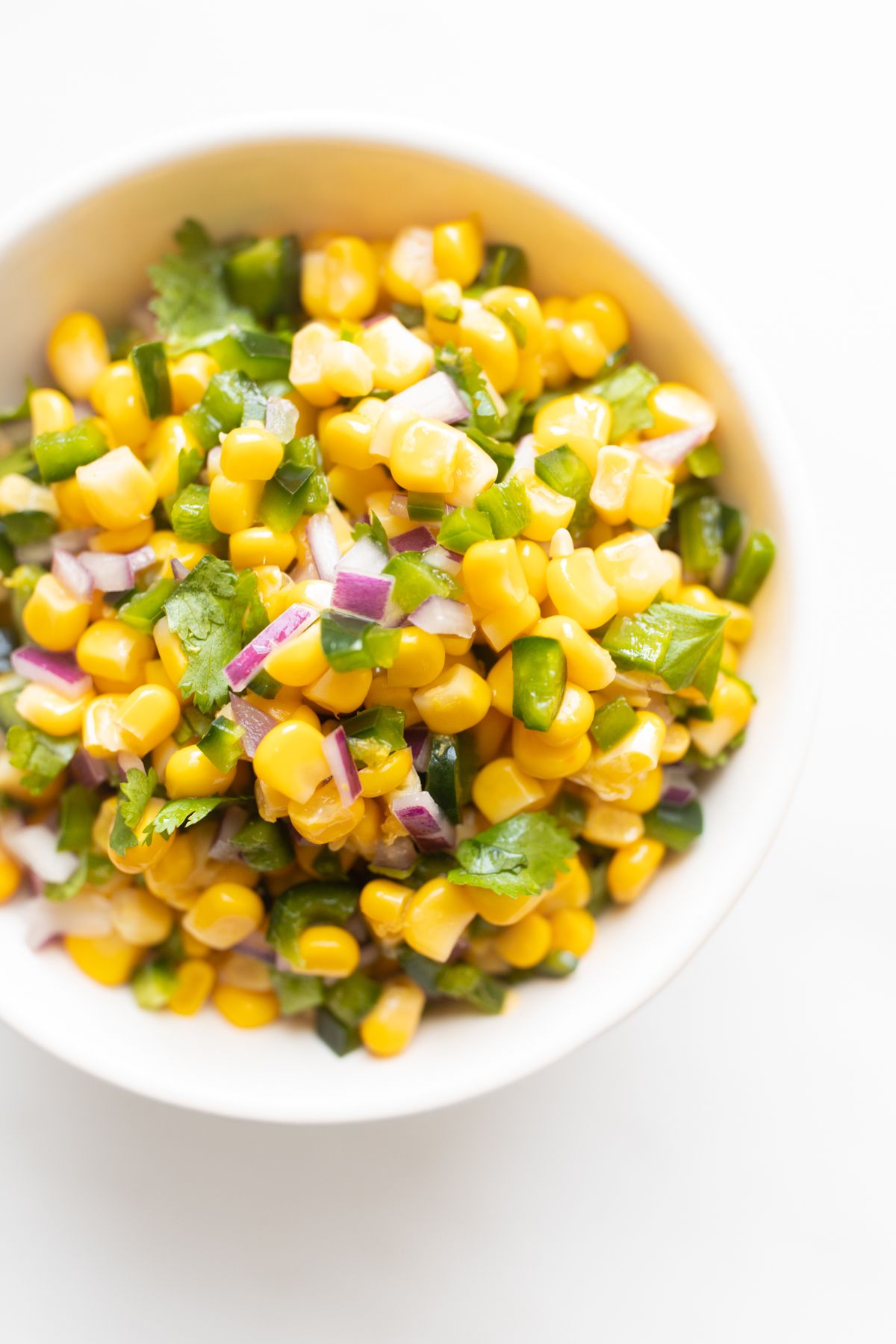 A white bowl full of homemade Chipotle corn salsa.