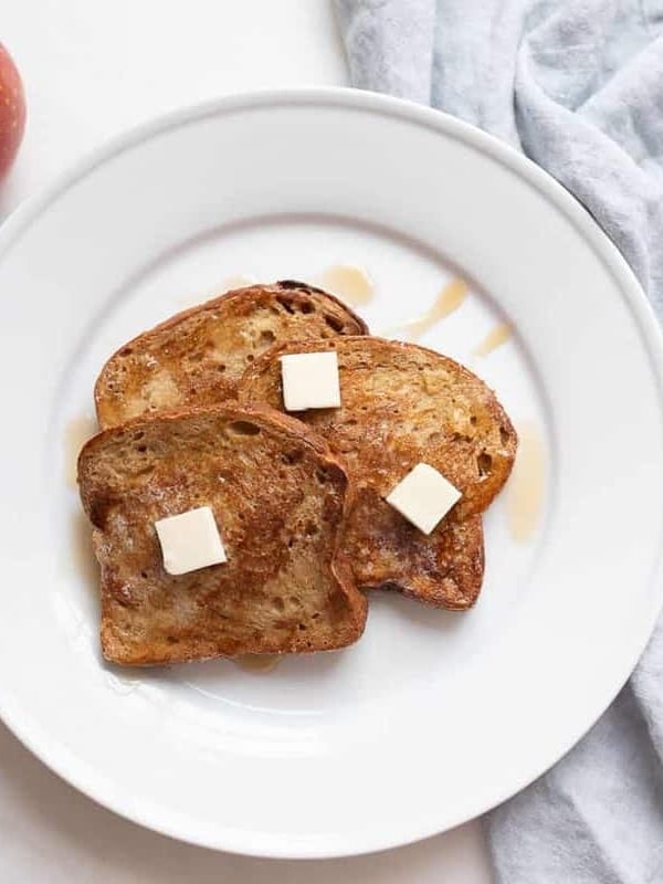 A white plate with slices of apple fritter french bread.