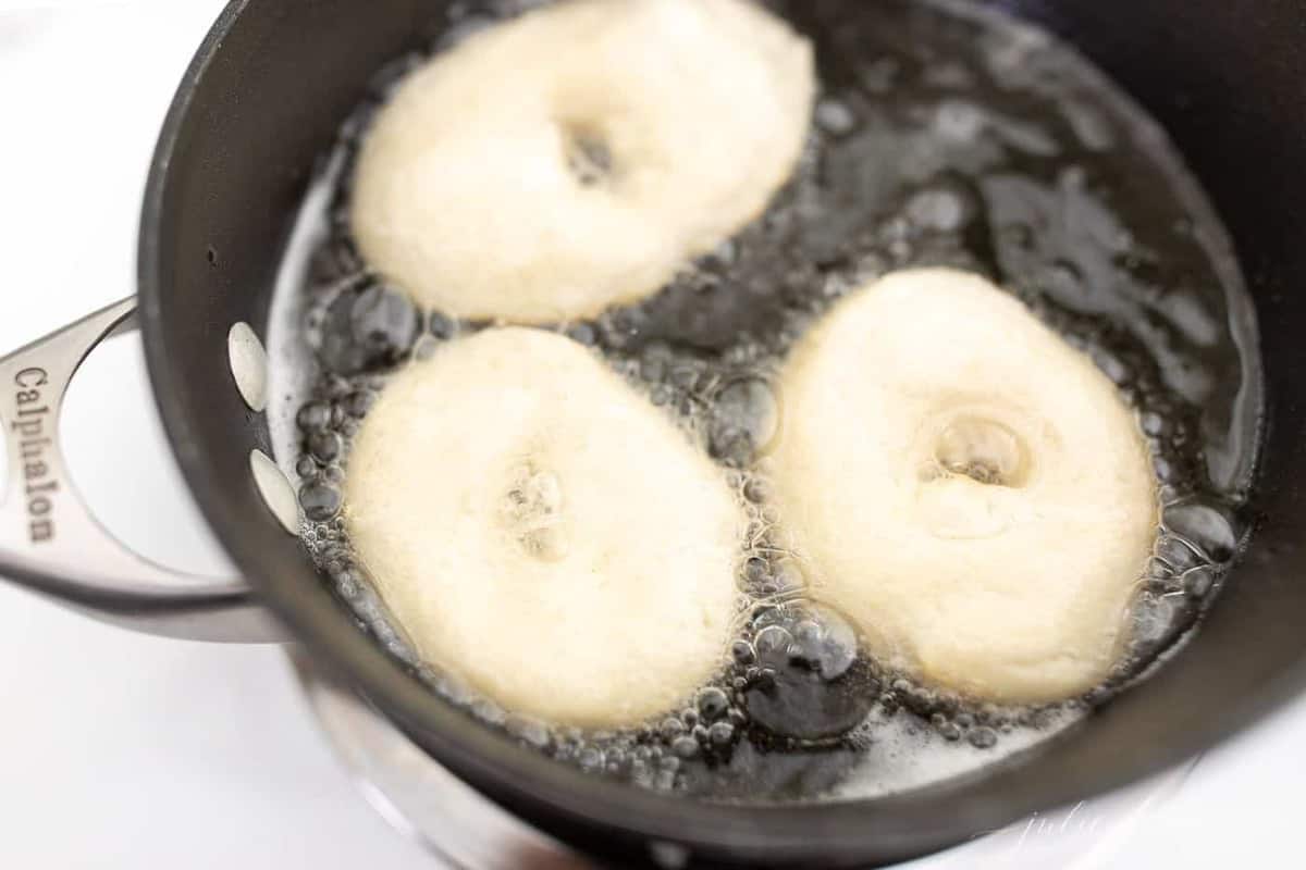 A sauce pan filled with oil frying easy homemade donuts.