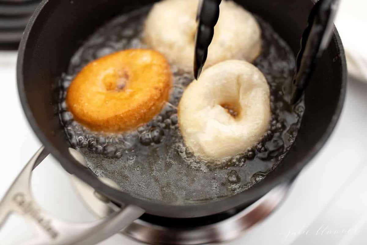 A sauce pan filled with oil frying easy homemade donuts.