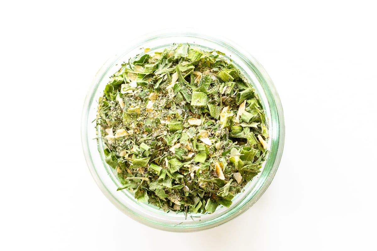 Glass jar of homemade ranch seasoning on a white countertop.