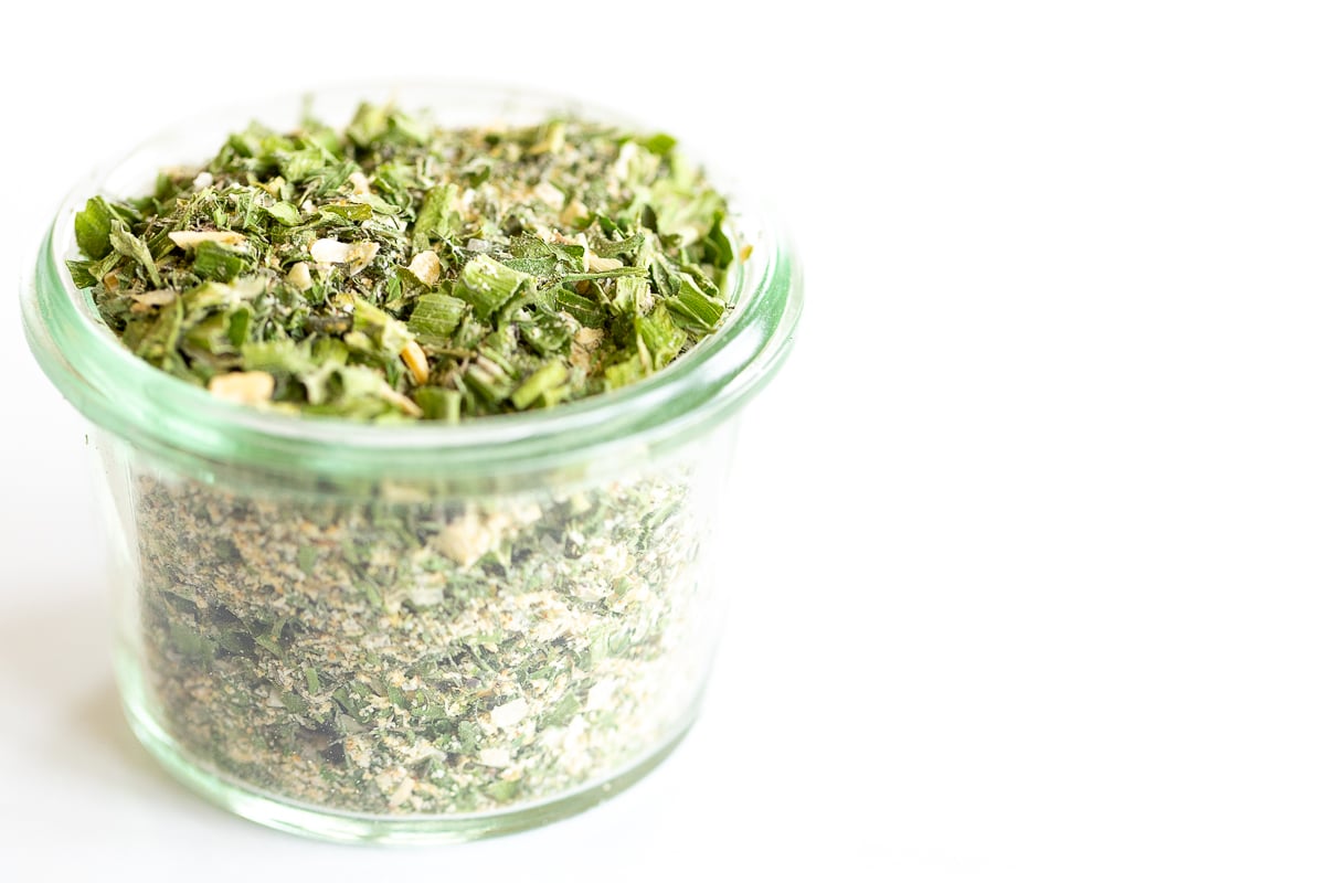 Glass jar of homemade ranch seasoning on a white countertop.