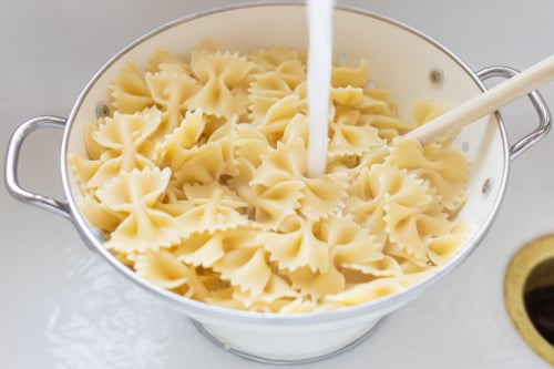 Bow tie pasta in a colander in a sink