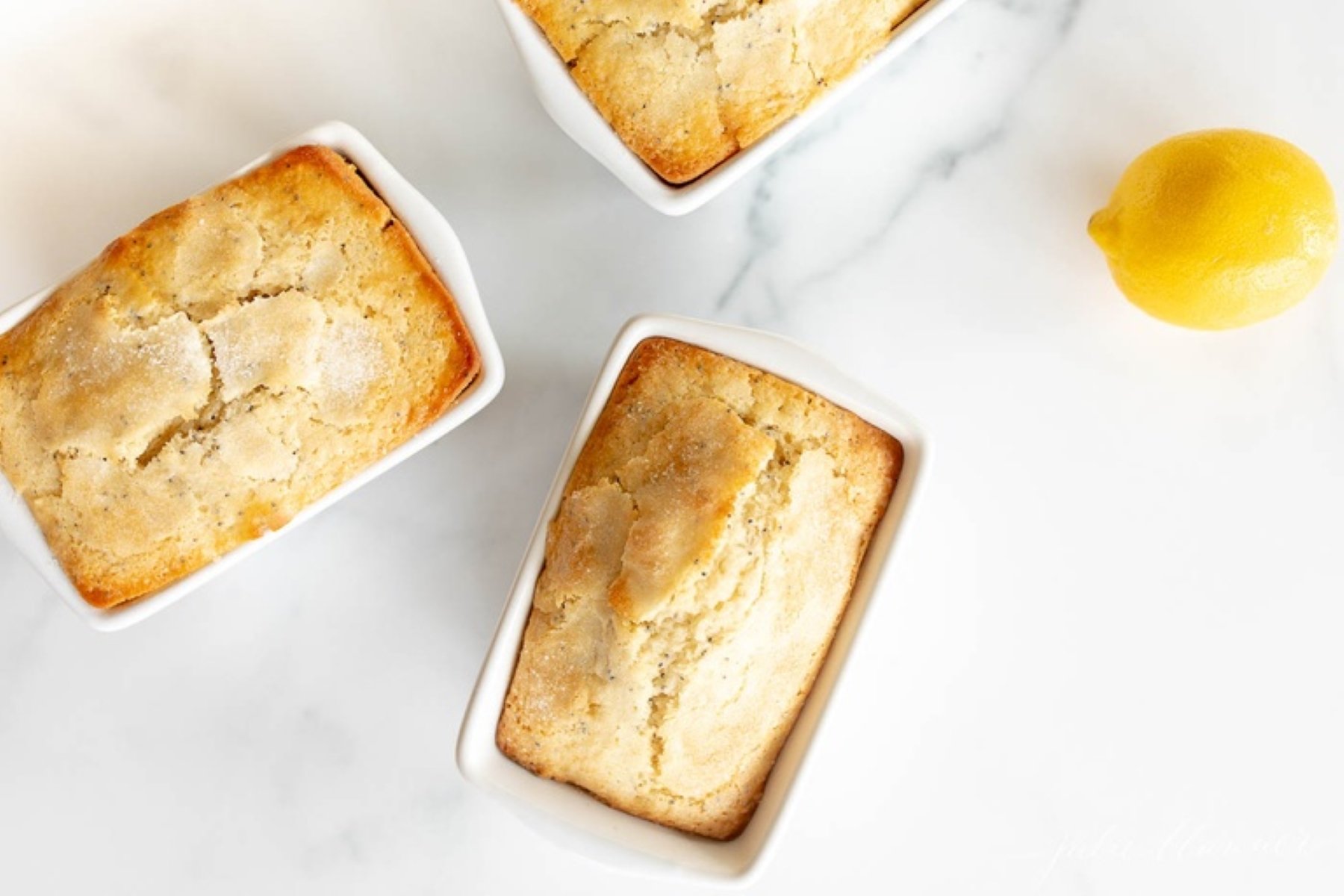 Small lemon poppy seed loaf in white ceramic loaf pans.