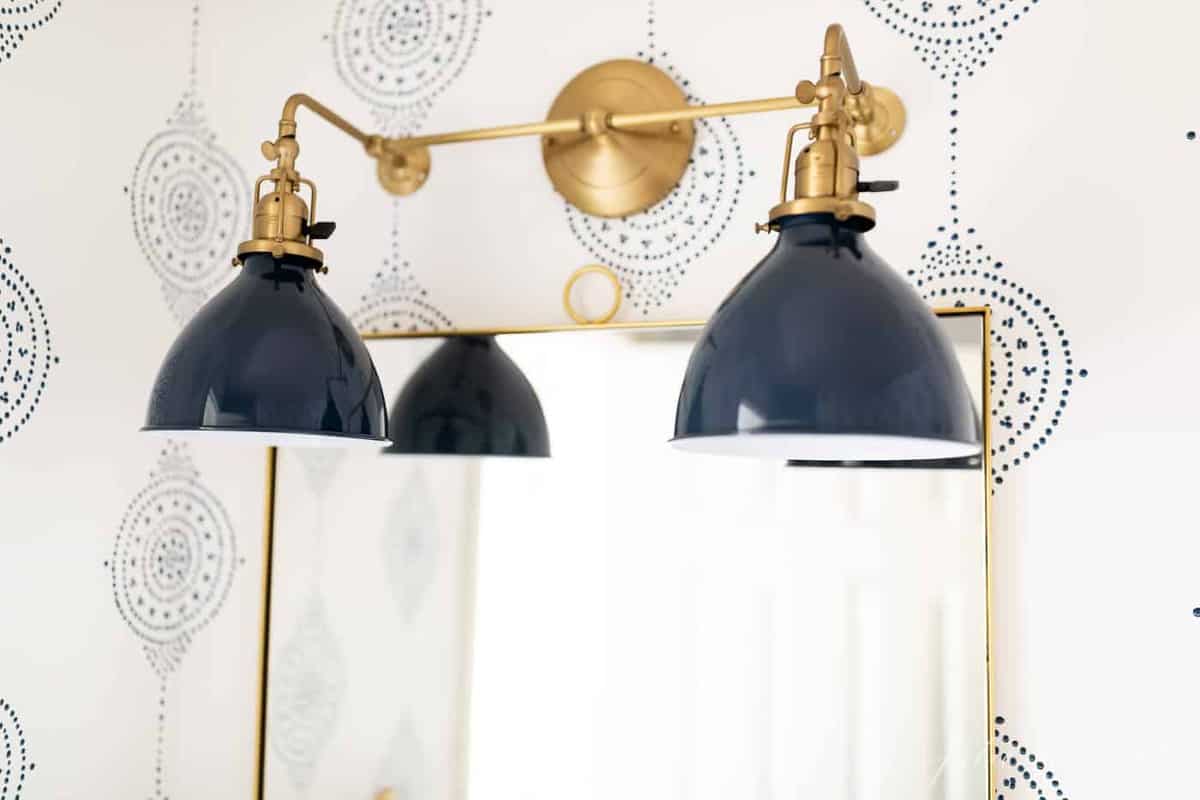 A navy and brass bathroom light fixture in a modern bathroom idea refresh.