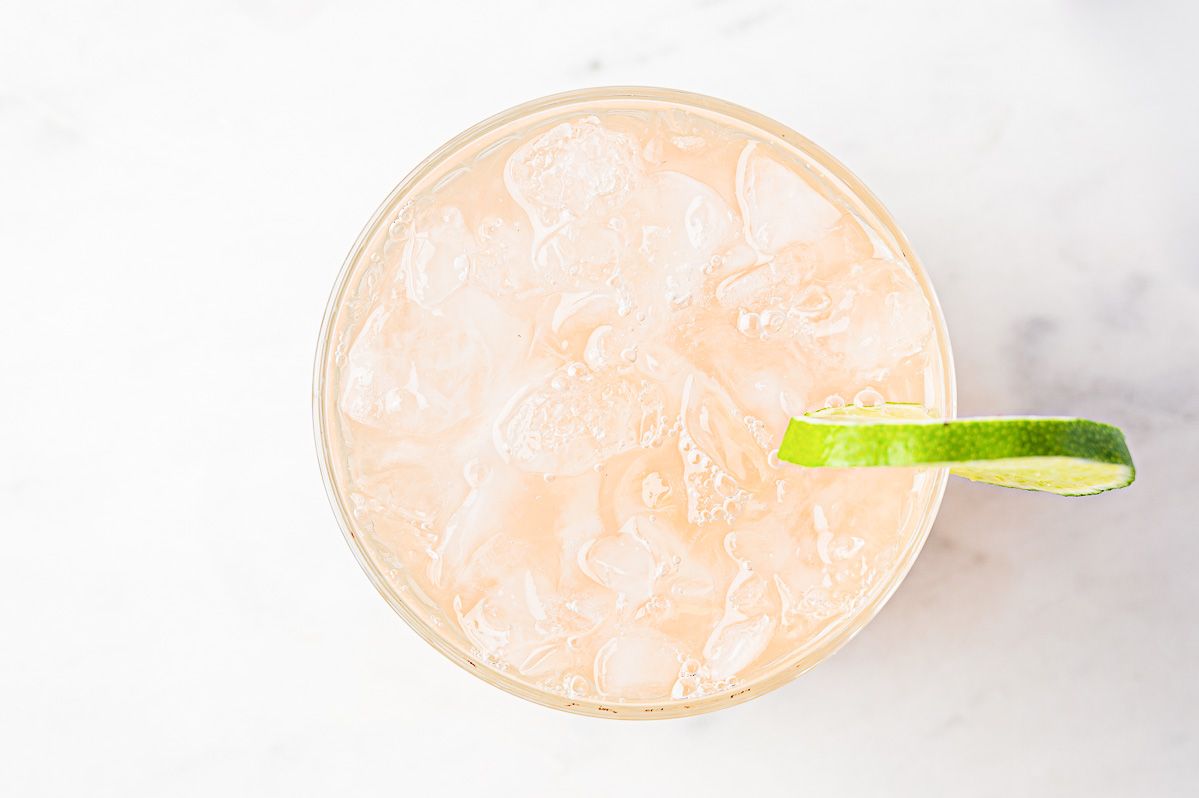 A paloma recipe on a marble surface with a slice of lime for garnish