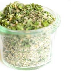 Glass jar of homemade ranch seasoning on a white countertop.